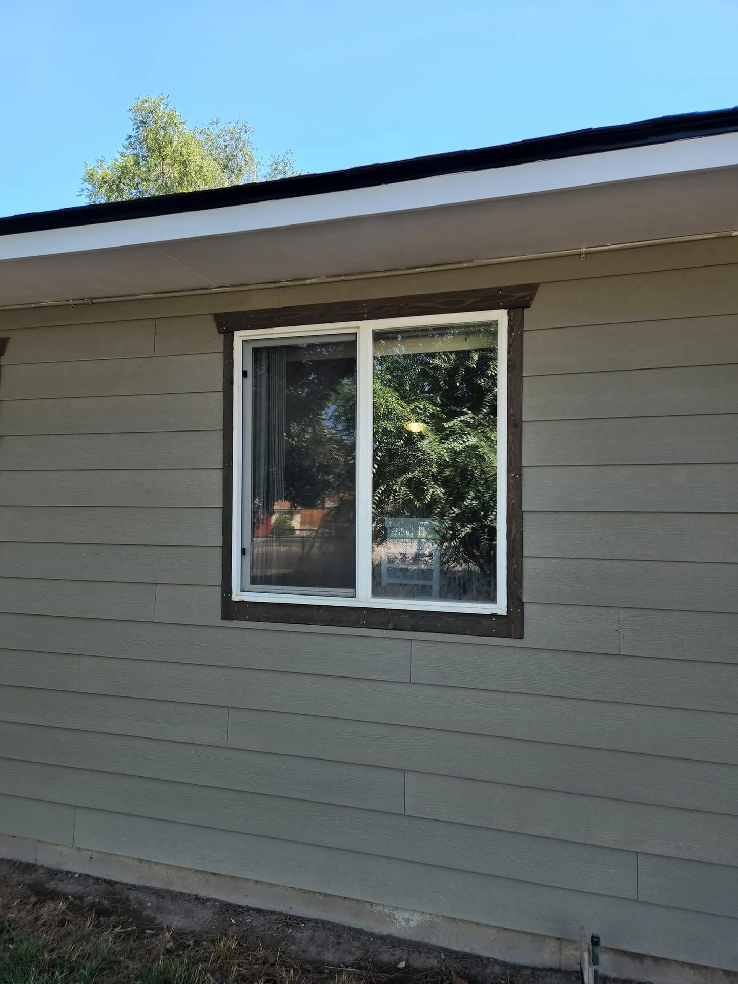 New gray lap siding with a trimmed window